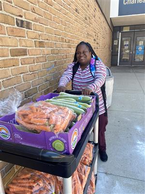 Student pushing carrots and cucumbers on a cart